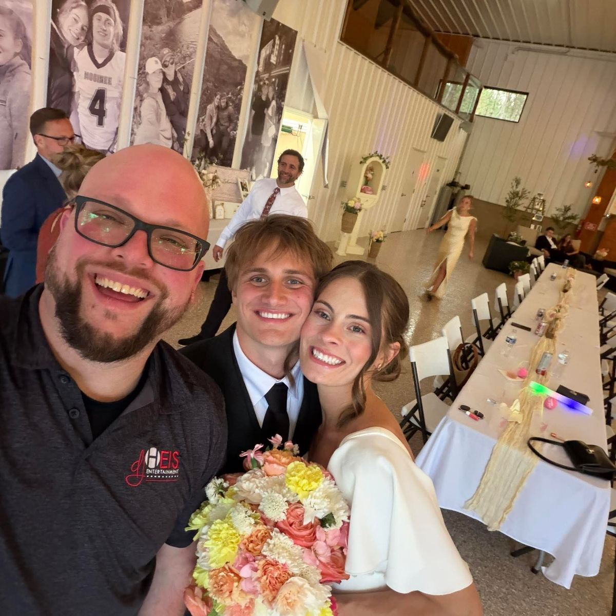 A bride and groom celebrating with Anthony on their wedding day